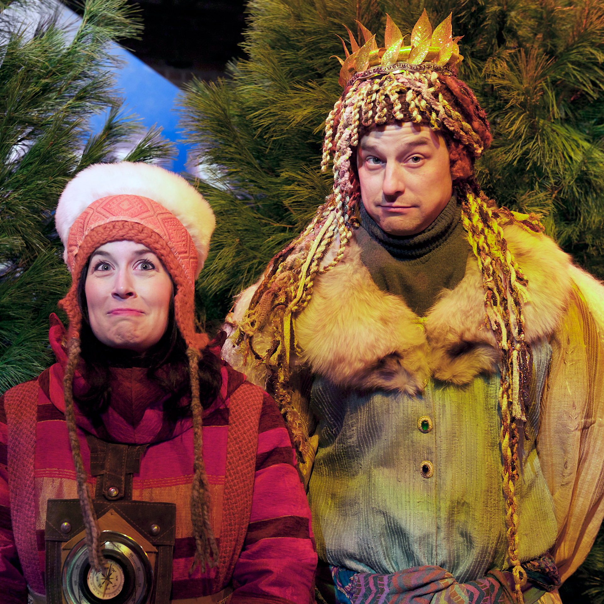 A man in a turkey costume stands behind a woman in winterwear.